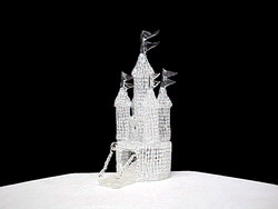this is a round knitted glass Castle with five towers and a drawbridge wedding cake top