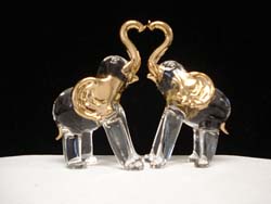 two glass elephants making a heart with their trunks wedding cake topper